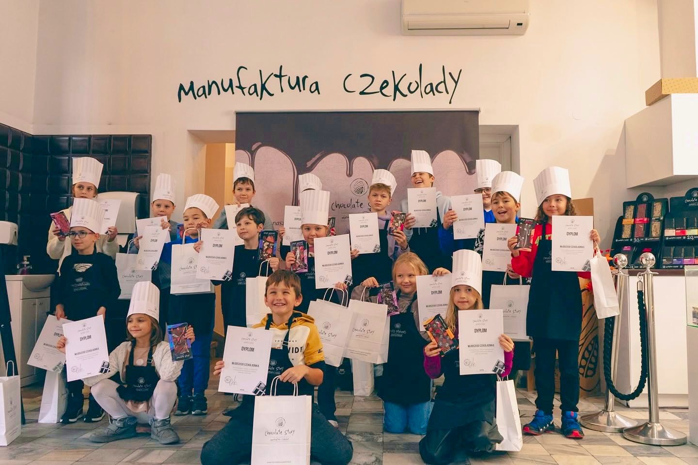 Wnętrze Czekoladziarni przy Marszałkowskiej — grupa z dyplomami na sali warsztatowej